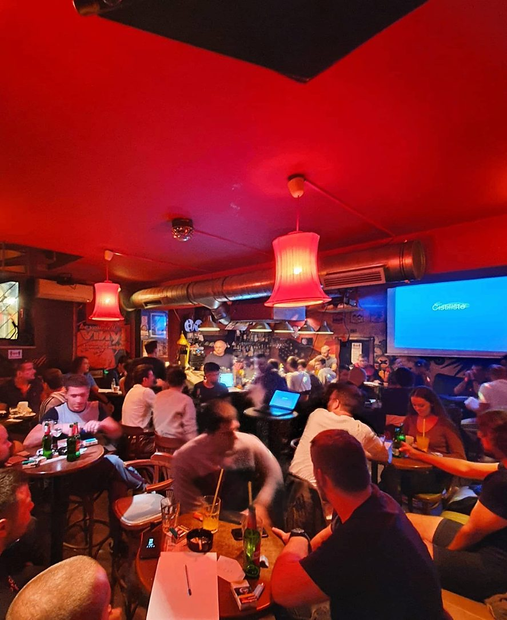 Crowded bar interior under red light
