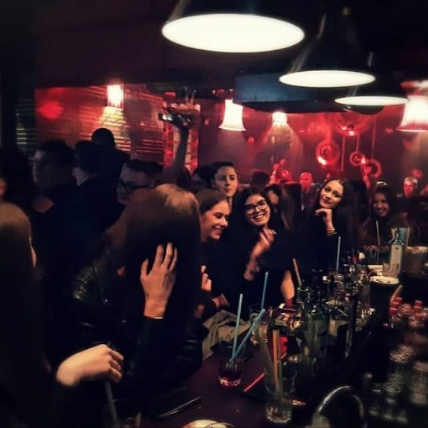 Guests at the bar counter under warm hanging lights