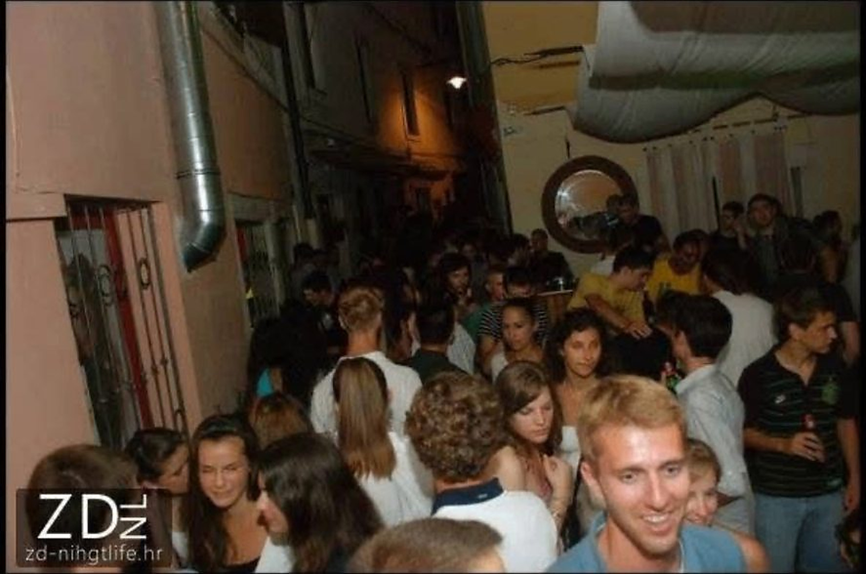 Crowd filling the alley outside the bar at night