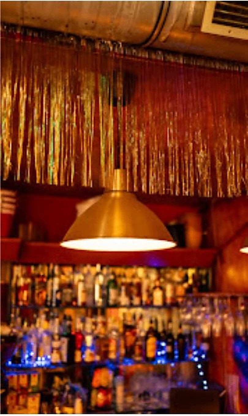 The bar shelves and counter under warm gold light